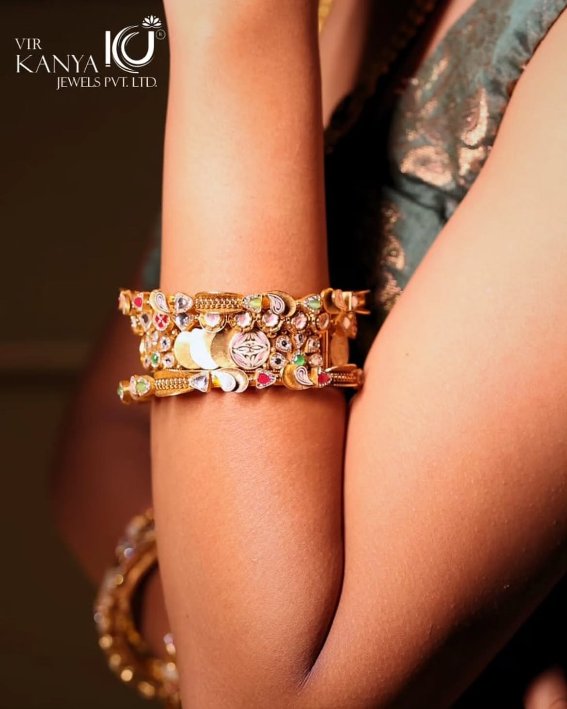 A stack of kundan and enamelled gold bangles on a model's wrist