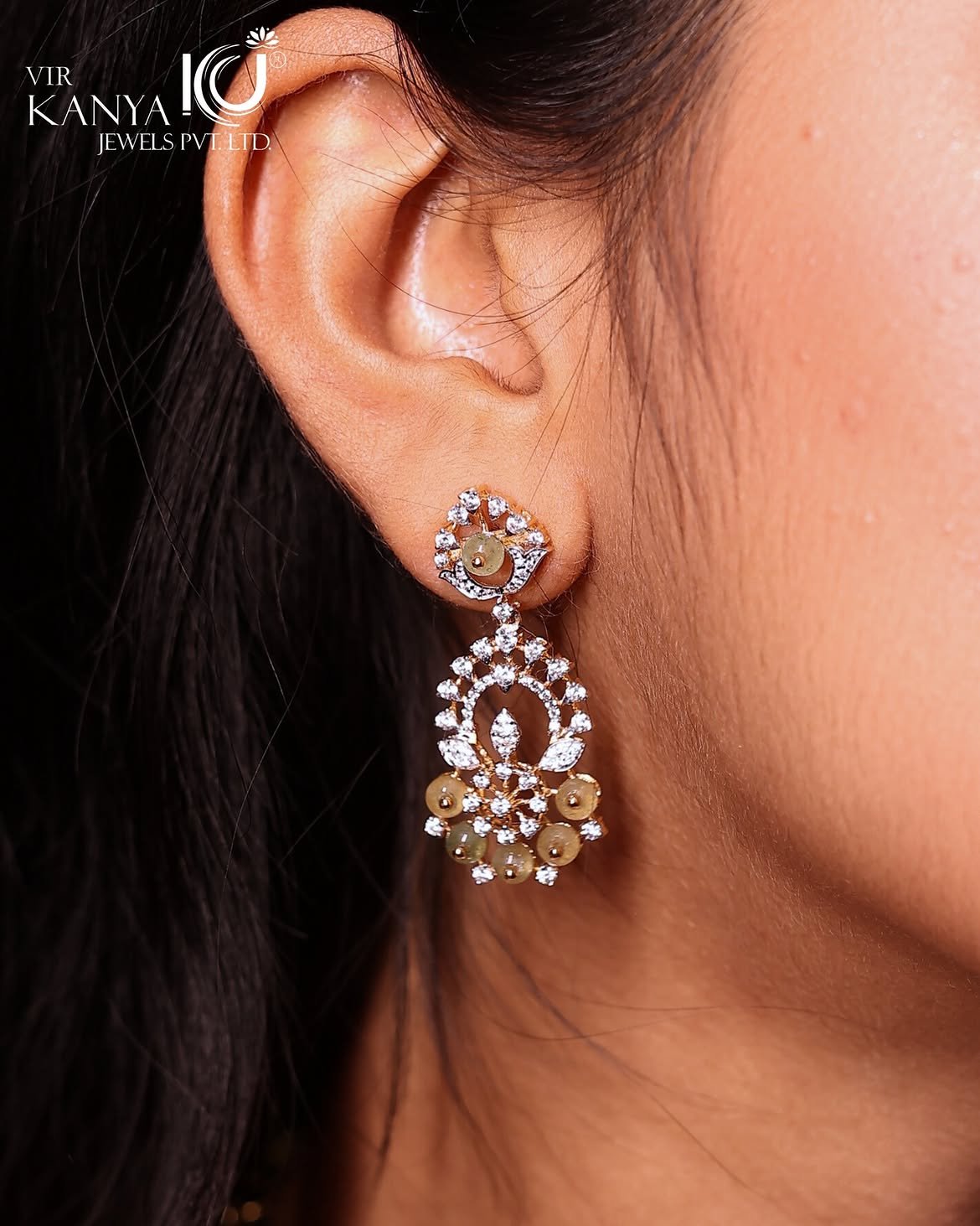 Close-up of a gold drop earring worn by a model